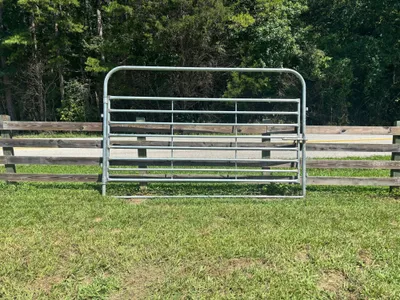Galvanized 12-foot heavy bow gate in front of a wood fence