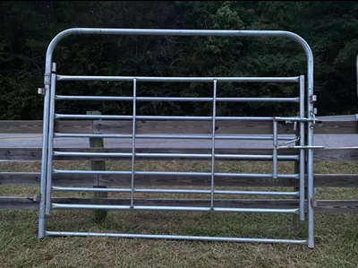 Galvanized sweep gate for a sweep tub, in front of a wood fence