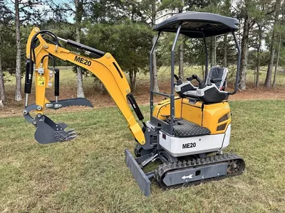 Yellow ME20 diesel mini excavator with canopy and hydraulic thumb, side view in a field