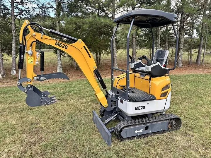 Yellow ME20 diesel mini excavator with canopy and hydraulic thumb, side view in a field