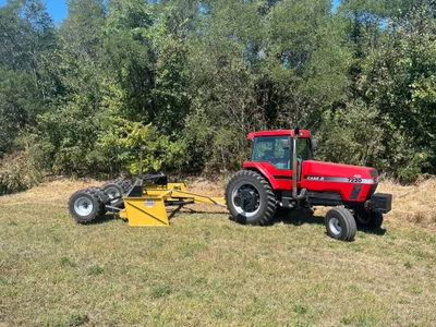 Red Case IH tractor pulling a yellow Reif V-Shape Box Scraper in a field