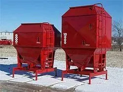 Two red stationary bulk feed bins on steel legs