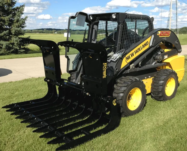 EZ Grapple on a New Holland skid steer in a grassy yard