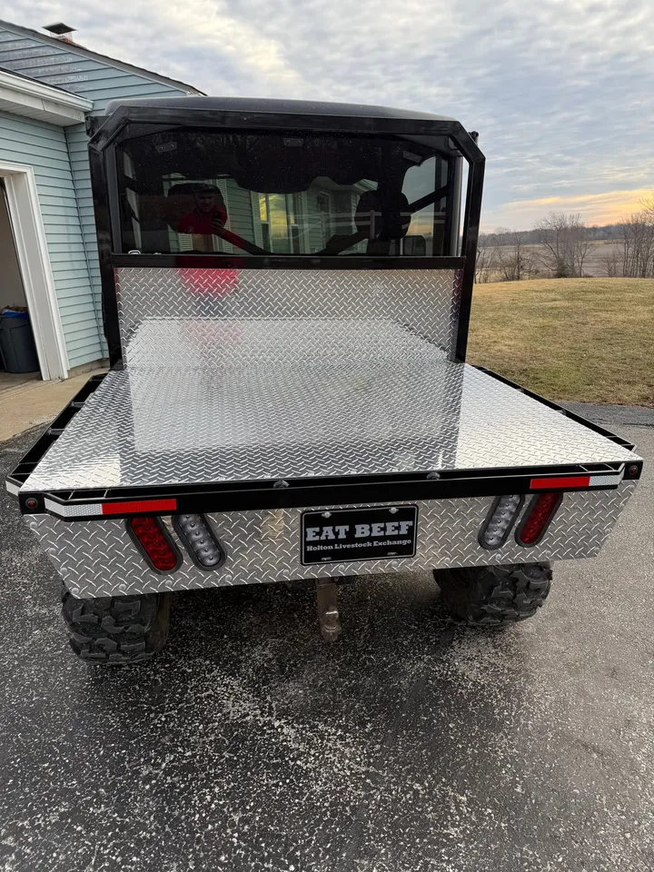 Flat bed on a side by side, rear view with tail lights